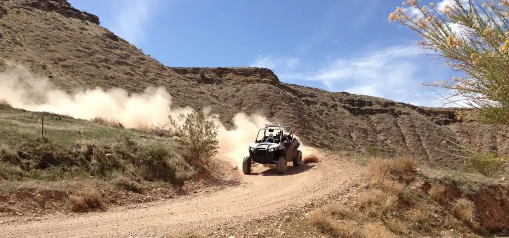 UTV driving fast on dirt road