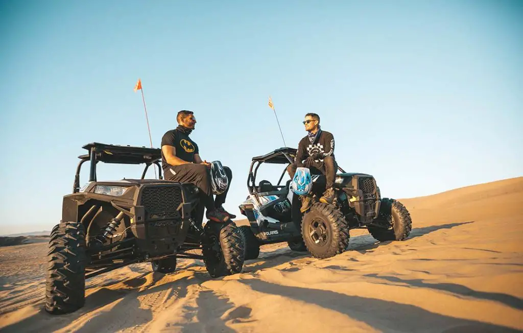 Two UTVs on sand dunes