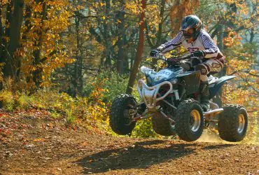 Sport quad riders jump when riding on a forest road