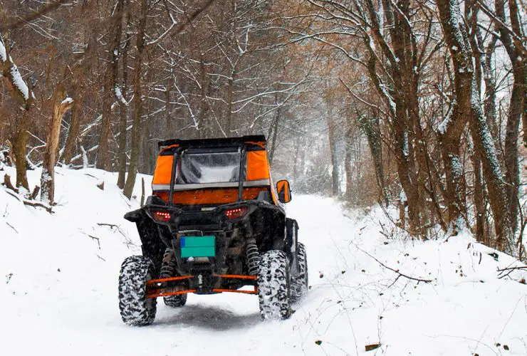 UTV driving in snow, winter kitted with windshield and cabin cover